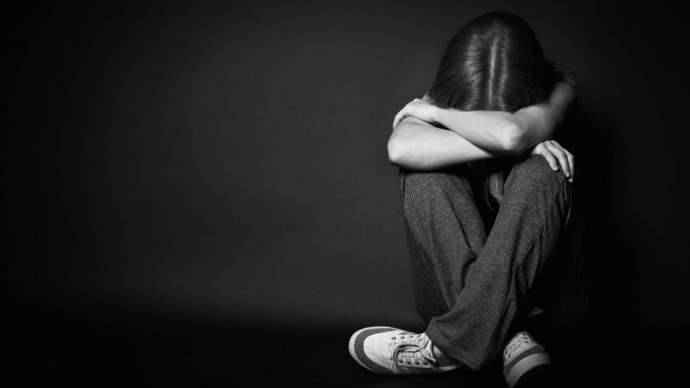 depressed girl sitting with her head down