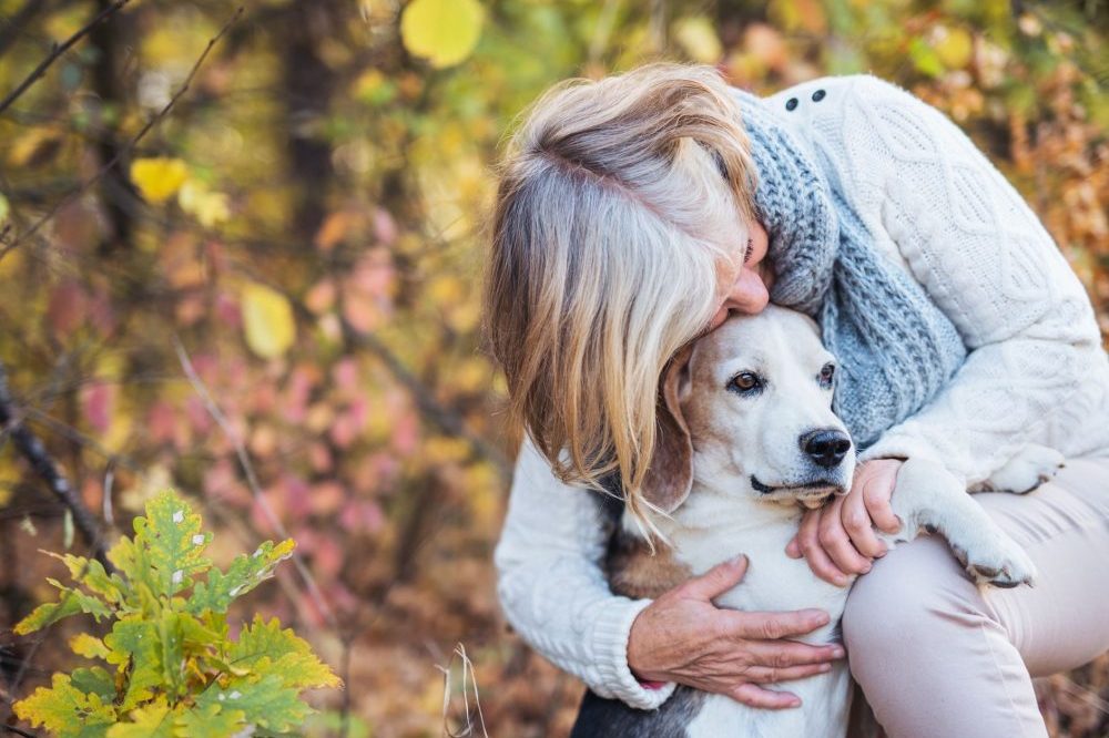 Older woman cuddling her older dog