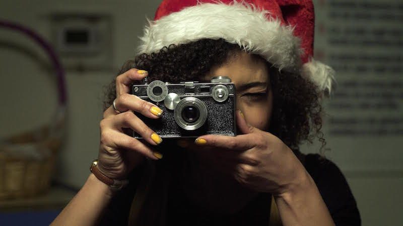 woman in santa hat taking photo