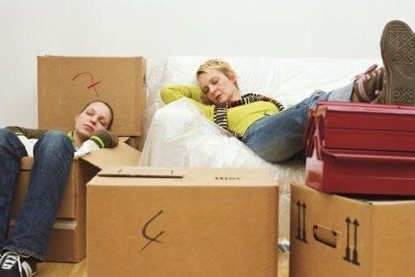 2 women sitting amongst boxes