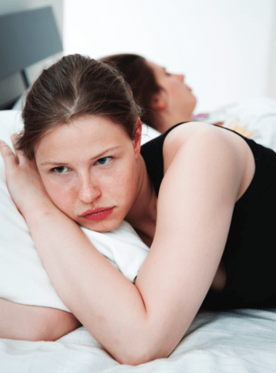 2 women in bed lying back to back