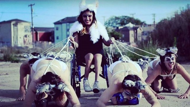 Woman in a wheelchair being pulled by 4 other women