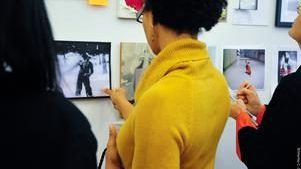 woman in yellow top looking at wall art