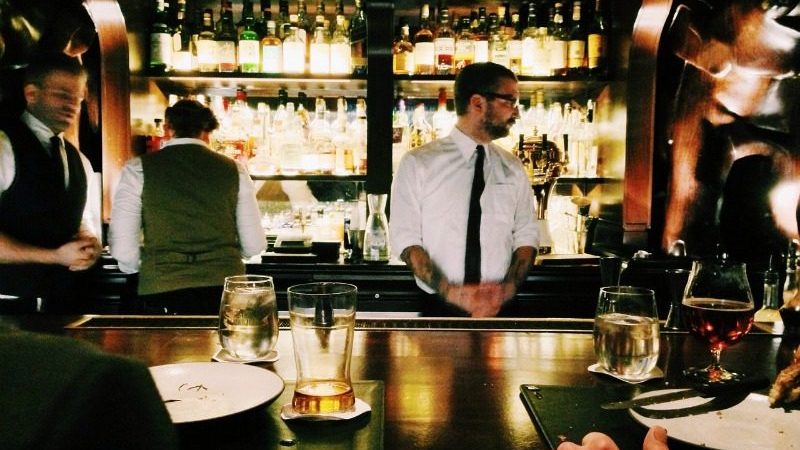 Male bartender behind a bar