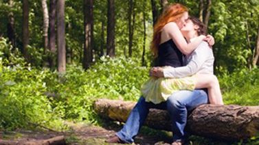 2 women kissing in forest