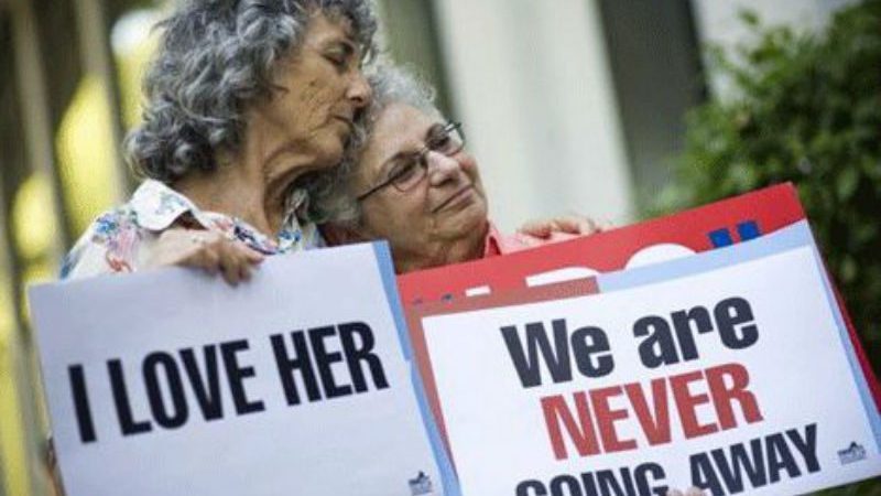 2 older Lesbians holding up signs