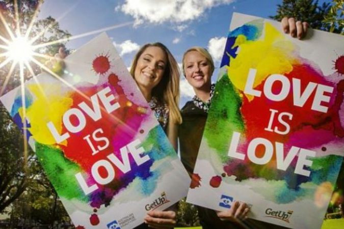 2 Women holding up poster 