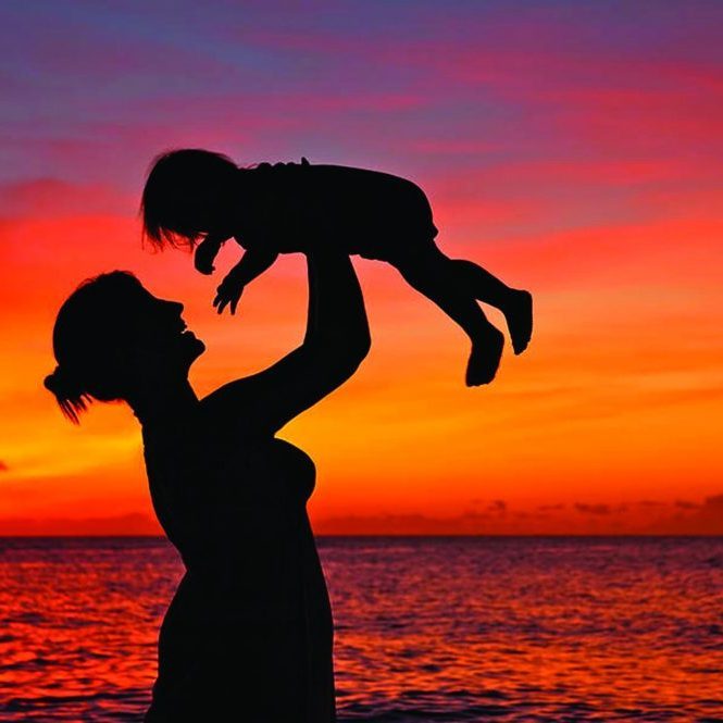 Mother holding a toddler up in the air